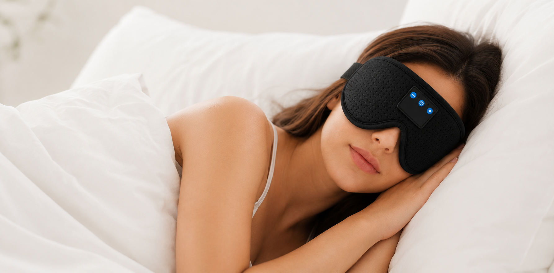 A woman lying in bed under white covers, wearing a black sleep mask with small blue illuminated indicator lights on the side.